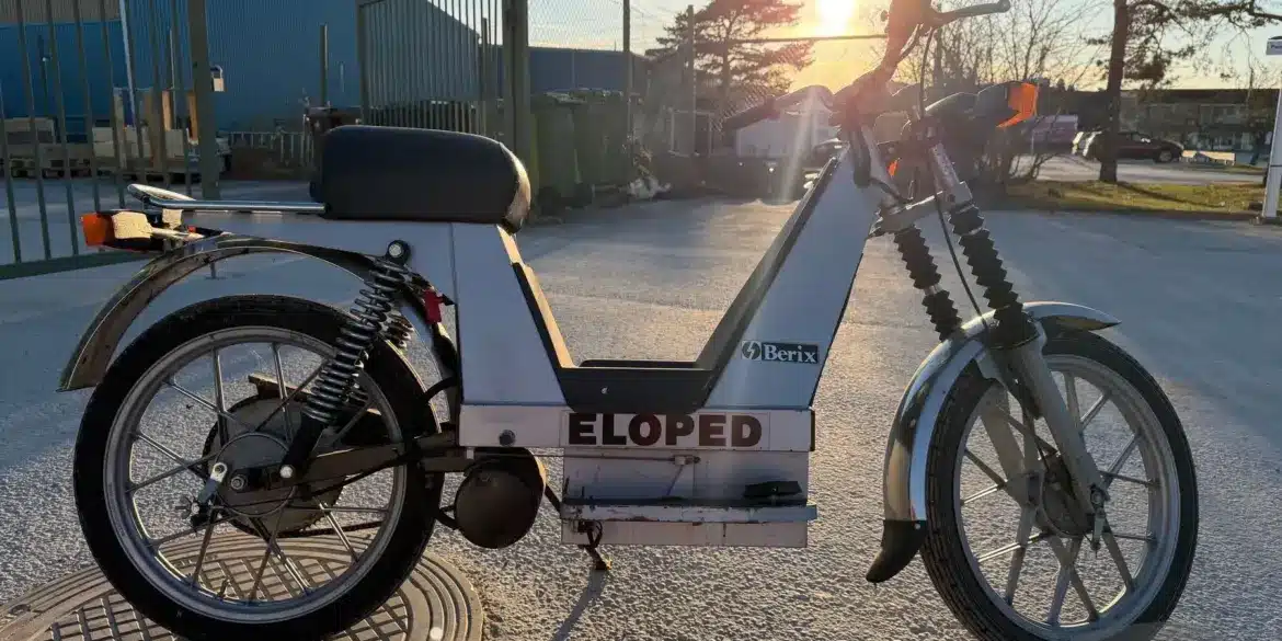 Seitenansicht eines Berix Eloped Elektromopeds aus den 1980er-Jahren, aufgenommen im Außenbereich bei Sonnenuntergang.