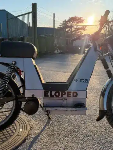 Seitenansicht eines Berix Eloped Elektromopeds aus den 1980er-Jahren, aufgenommen im Außenbereich bei Sonnenuntergang.