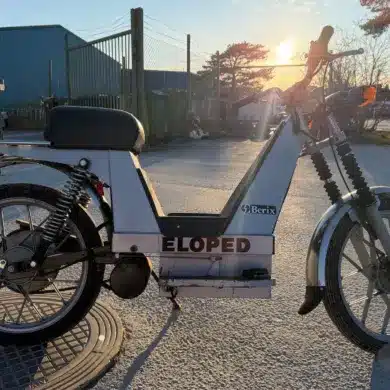 Seitenansicht eines Berix Eloped Elektromopeds aus den 1980er-Jahren, aufgenommen im Außenbereich bei Sonnenuntergang.