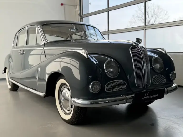 BMW 502 V8 Barockengel Baujahr 1959 in dunkelgrau, Seitenansicht mit Schiebedach und charakteristischer Kühlerfigur in einer hellen Ausstellungshalle