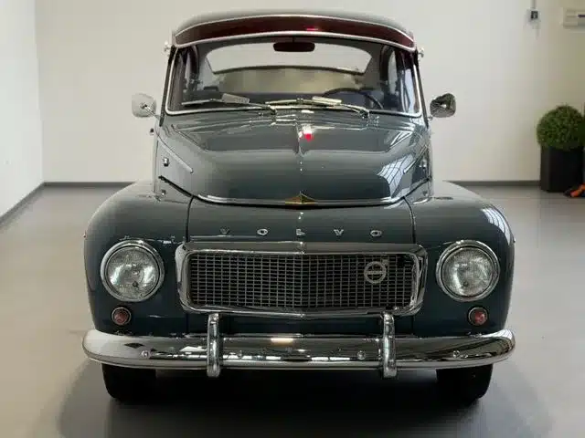 Volvo PV544, grau-blau, Baujahr 1961, fotografiert frontal in einer Halle.