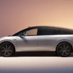 Li Auto i6 in Seitenansicht, silberfarbenes Elektro-SUV mit stromlinienförmigem Design vor sanftem Farbverlauf-Hintergrund.