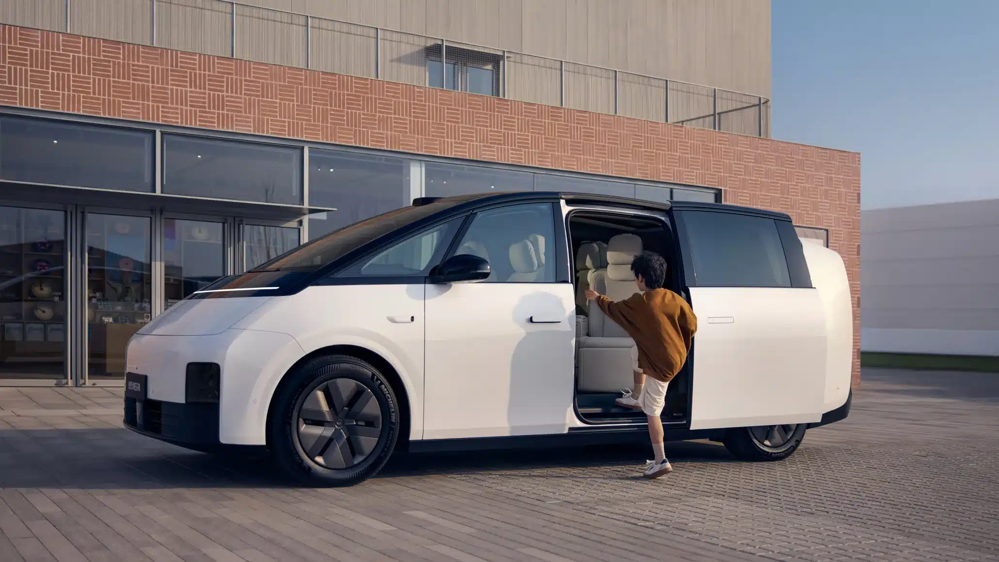 Li MEGA Elektro-Van mit offenem Einstieg und Kind an der Schiebetür