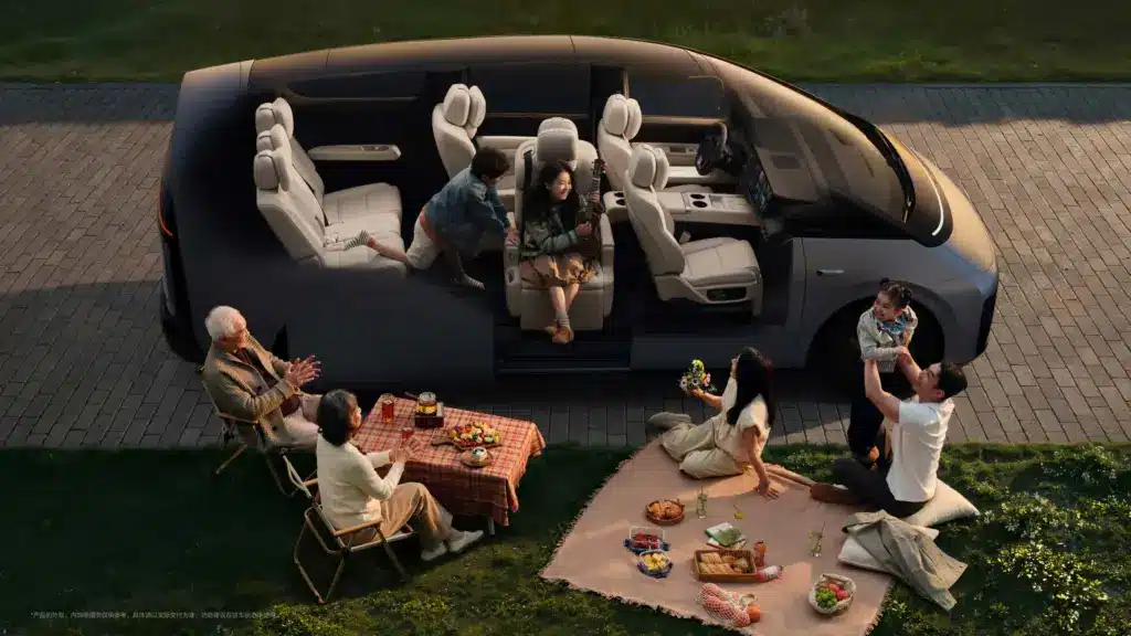 Li MEGA Familienvan mit geöffneten Türen, sieben Sitzplätzen und Familie beim Picknick