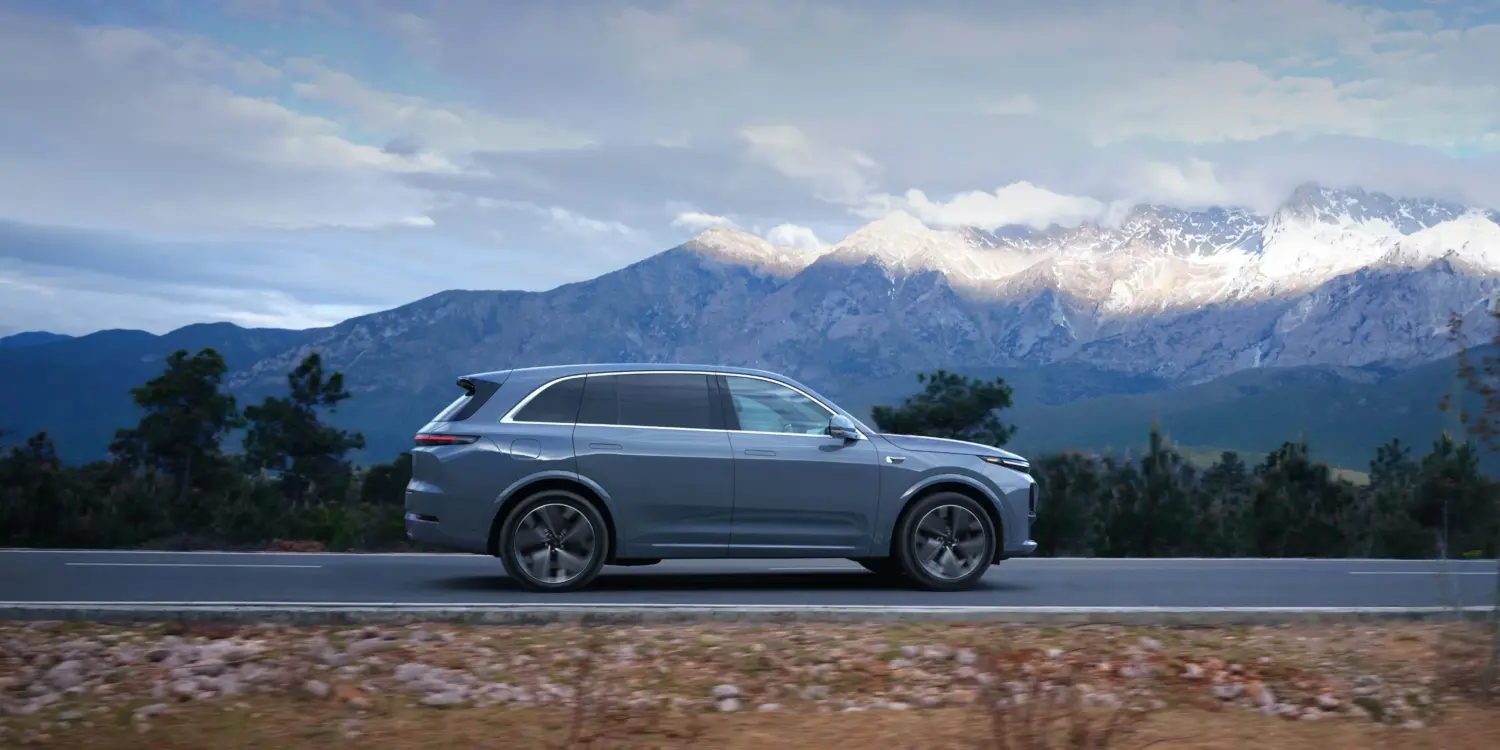 Grauer Li L7 SUV von der Seite auf Straße mit Gebirgslandschaft im Hintergrund