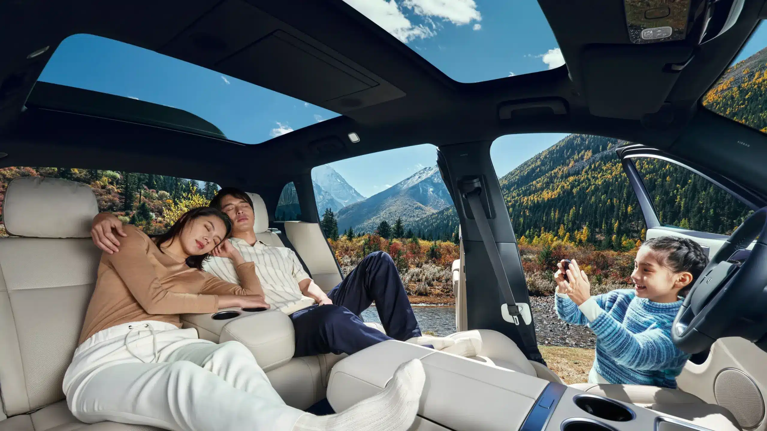 Familie entspannt im Queen-Seat-Modus des Li L7 mit offenem Panoramadach und Kind am Steuer