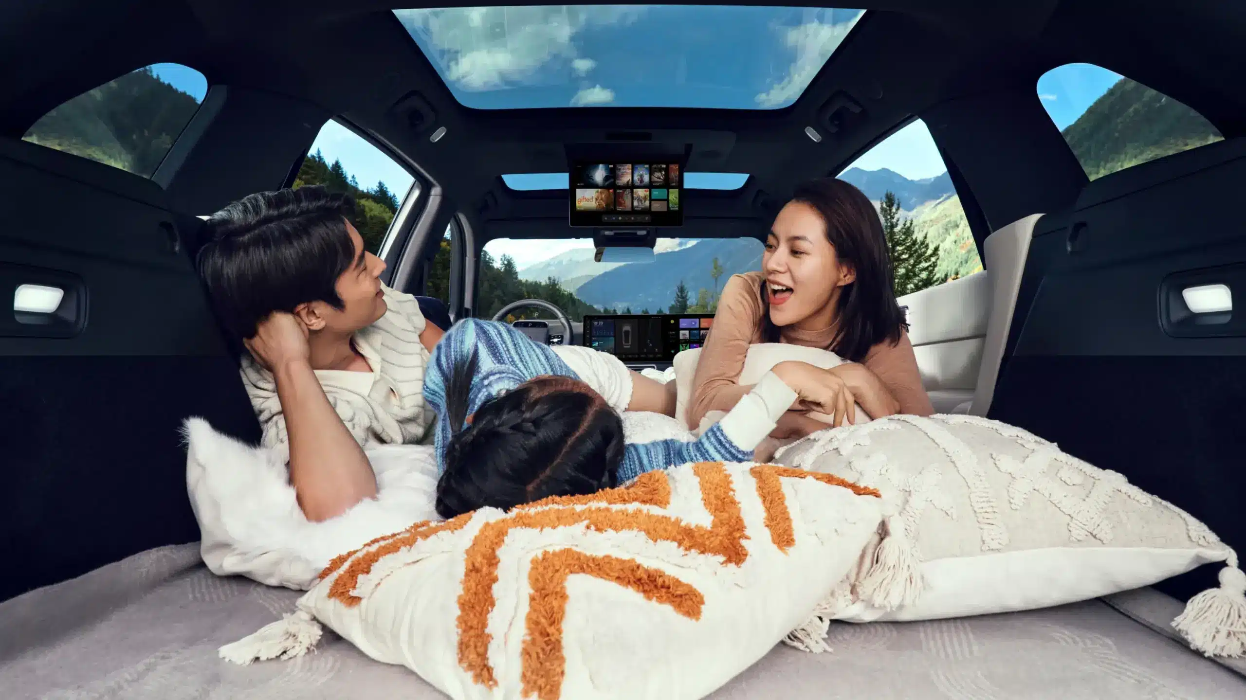 Familie nutzt den umgebauten Innenraum des Li L7 mit flachen Liegen, Panorama-Dach und Entertainment-System.