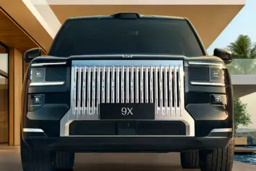 Zeekr 9X SUV von vorne mit prägnanter Chrom-Front und Lichtmatrix vor moderner Architektur mit Pool.