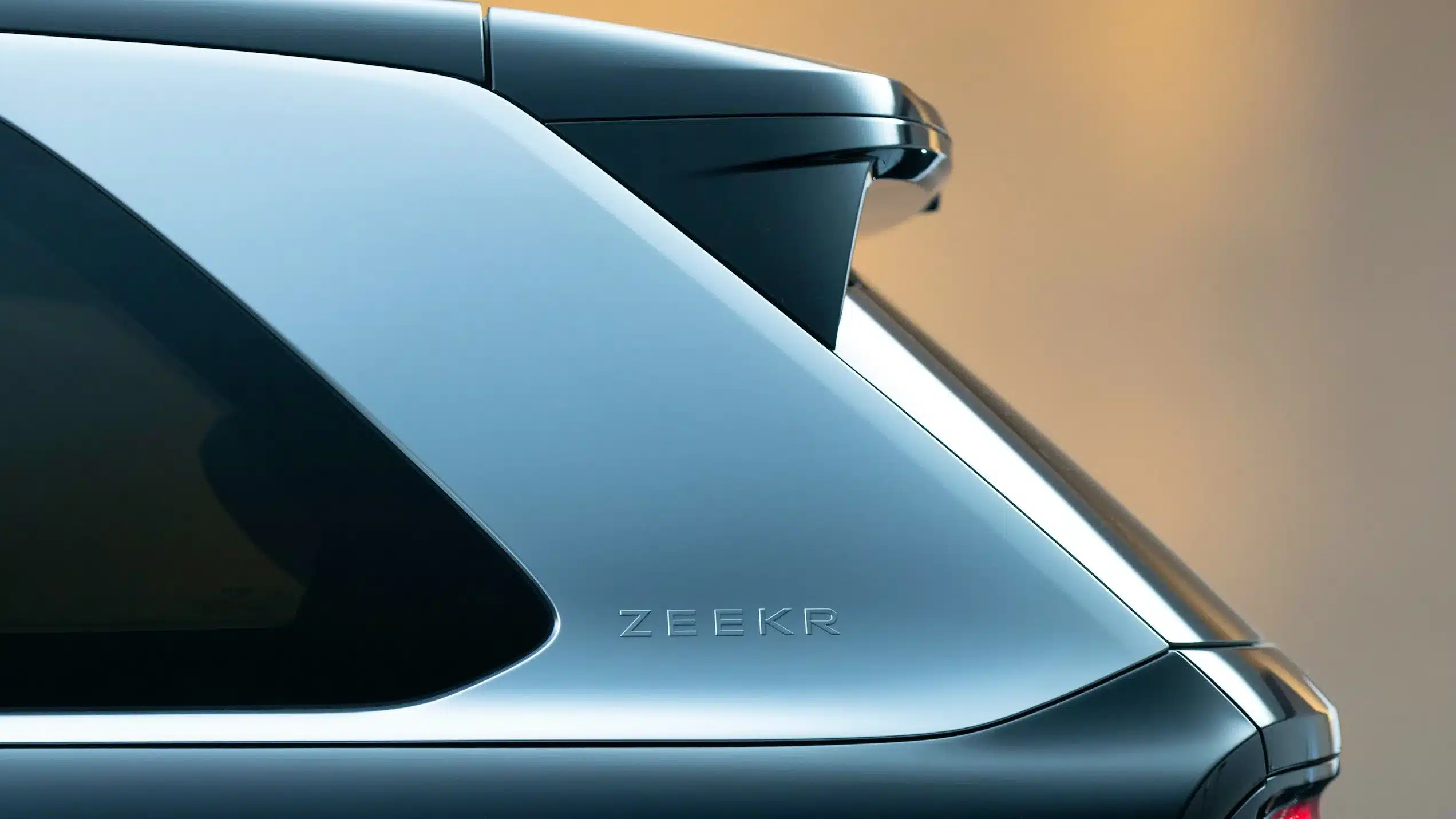 Detailansicht der hinteren Seitenpartie des Zeekr 9X mit Scheibe, Heckspoiler und ZEEKR-Schriftzug.
