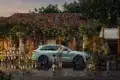 Li L6 SUV in hellblauer Lackierung, geparkt vor einem Blumenladen mit Familie und Katze im Vordergrund.