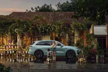 Li L6 SUV in hellblauer Lackierung, geparkt vor einem Blumenladen mit Familie und Katze im Vordergrund.
