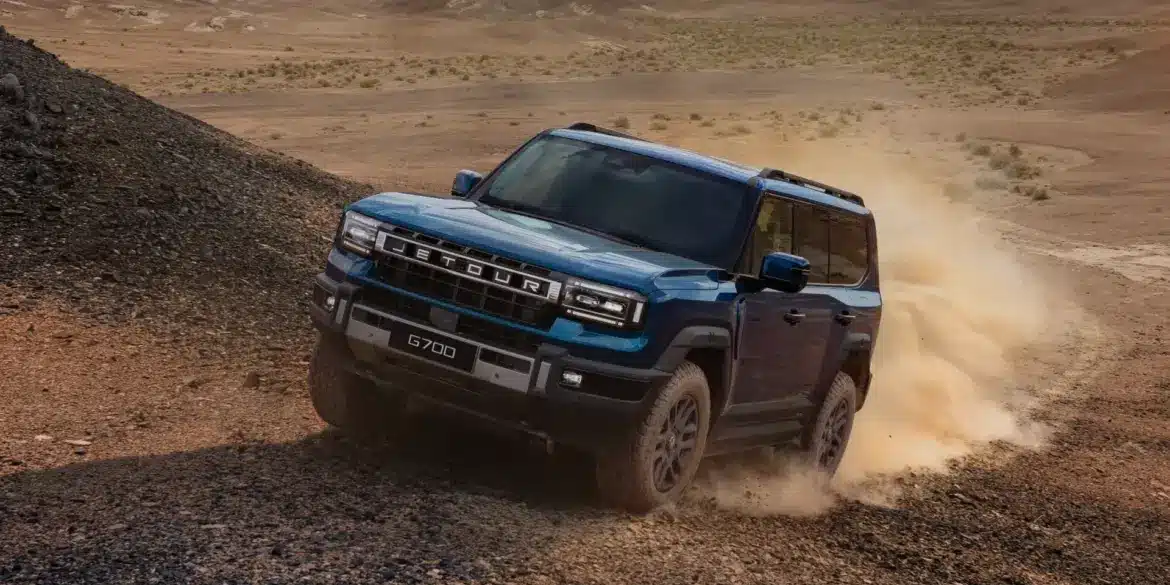 Jetour G700 fährt schräg eine Geröllpiste in einer Wüstenlandschaft hinauf