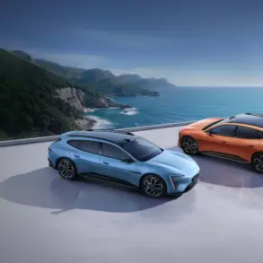 Zwei Avatr 06T Elektroautos, blau und orange, auf einer Plattform mit Blick aufs Meer und eine grüne Küstenlinie