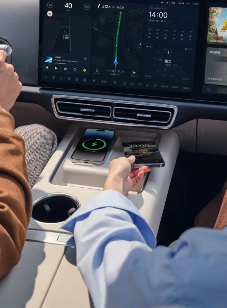 Innenraum des Li Auto L6 mit zentralem Infotainment-Display und kabelloser Ladefläche für Smartphones.