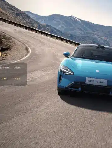 Xiaomi SU7 Max in Gulf Blue fährt dynamisch auf einer Gebirgsstraße, Frontansicht mit Leistungsdaten eingeblendet.