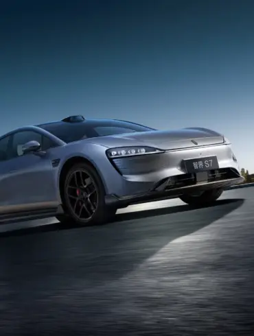 Zhijie S7 Elektroauto sportlich dynamisch auf offener Strecke vor Skyline bei Sonnenaufgang