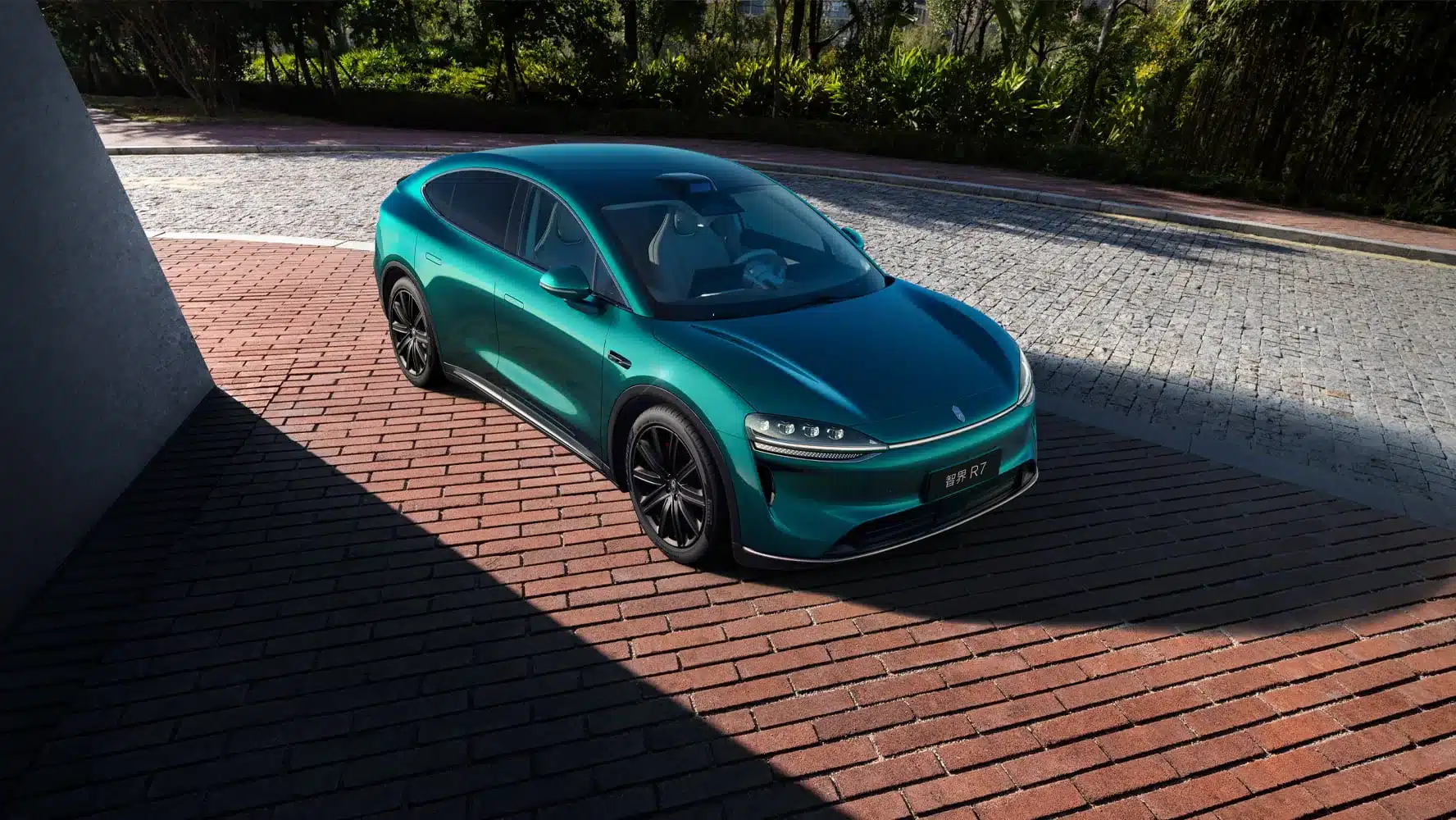Zhijie R7 Elektroauto in Türkis auf einer gepflasterten Auffahrt, von schräg oben fotografiert.