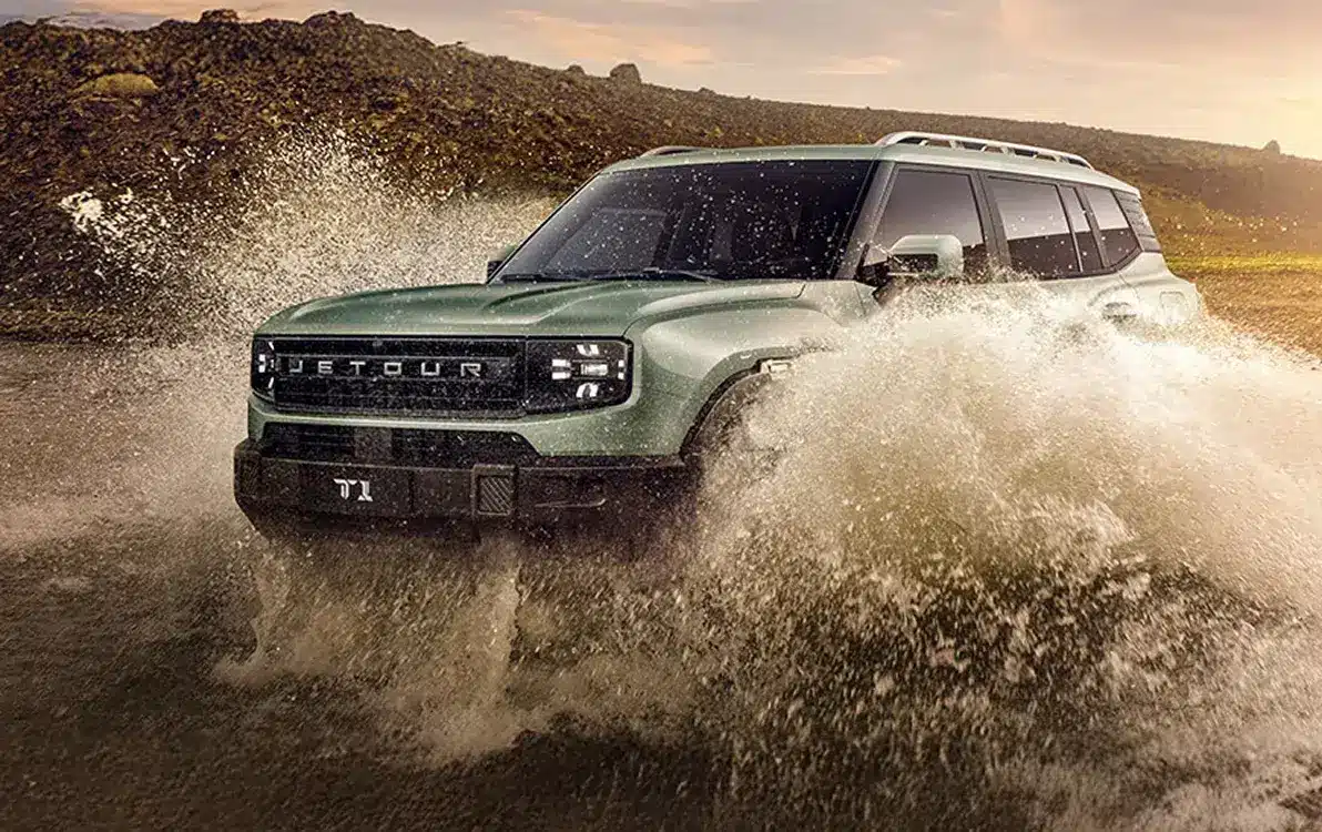 Ein Jetour T1 fährt durch tiefes Wasser in einer Offroad-Landschaft bei Sonnenuntergang.