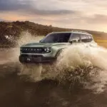 Ein Jetour T1 fährt durch tiefes Wasser in einer Offroad-Landschaft bei Sonnenuntergang.