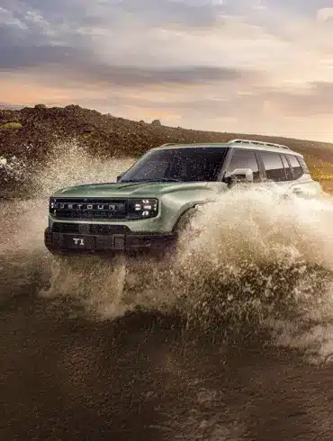 Ein Jetour T1 fährt durch tiefes Wasser in einer Offroad-Landschaft bei Sonnenuntergang.