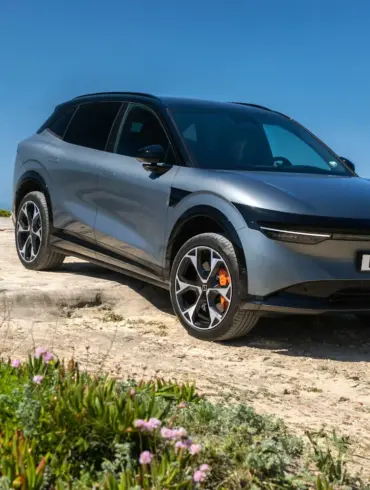 Silberner Zeekr 7X SUV geparkt auf einer Felsklippe mit Blick aufs Meer unter blauem Himmel.