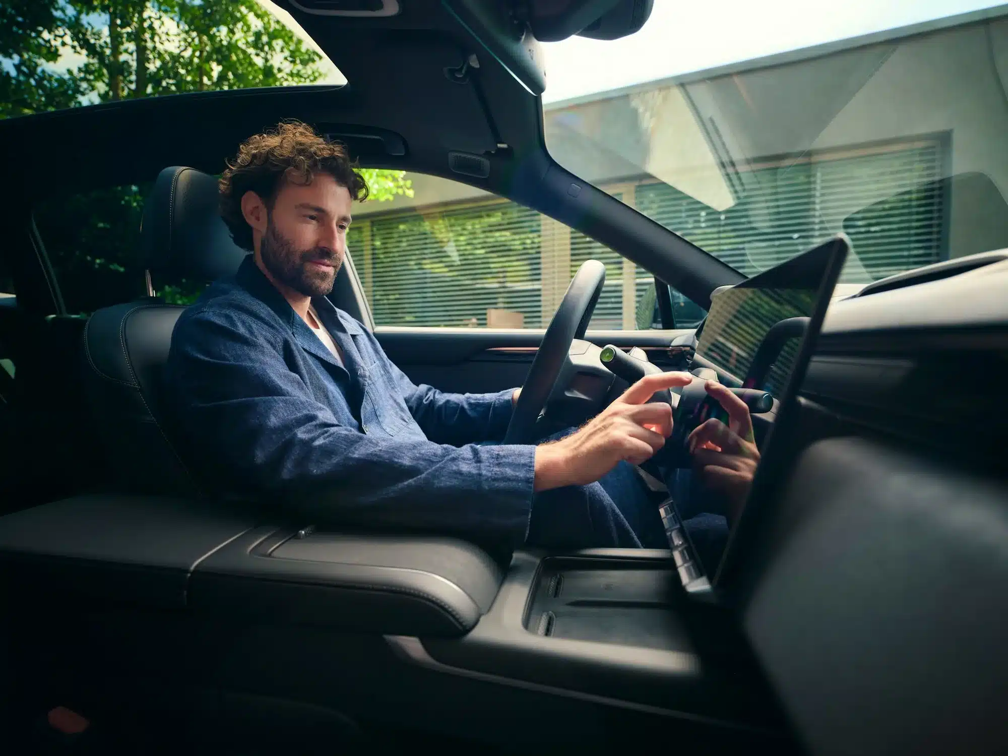 Mann bedient den Touchscreen im hochwertigen Innenraum eines Zeekr 7X Elektroautos.