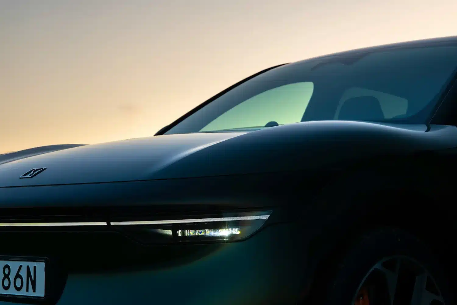 Detailaufnahme der Fahrzeugfront des Zeekr 7X mit Matrix-LED-Scheinwerfern bei Dämmerung.