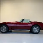 Chevrolet Corvette C3 Stingray Cabrio in tiefrotem Candy-Lack, Seitansicht, Klassiker der US-Sportwagenkultur.