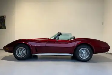 Chevrolet Corvette C3 Stingray Cabrio in tiefrotem Candy-Lack, Seitansicht, Klassiker der US-Sportwagenkultur.