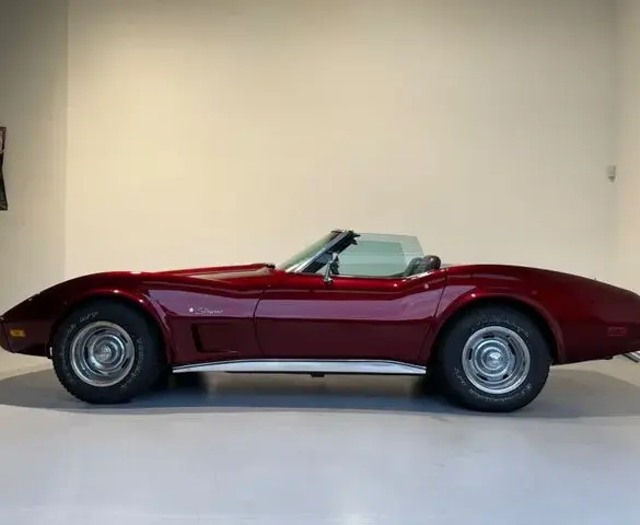 Chevrolet Corvette C3 Stingray Cabrio in tiefrotem Candy-Lack, Seitansicht, Klassiker der US-Sportwagenkultur.