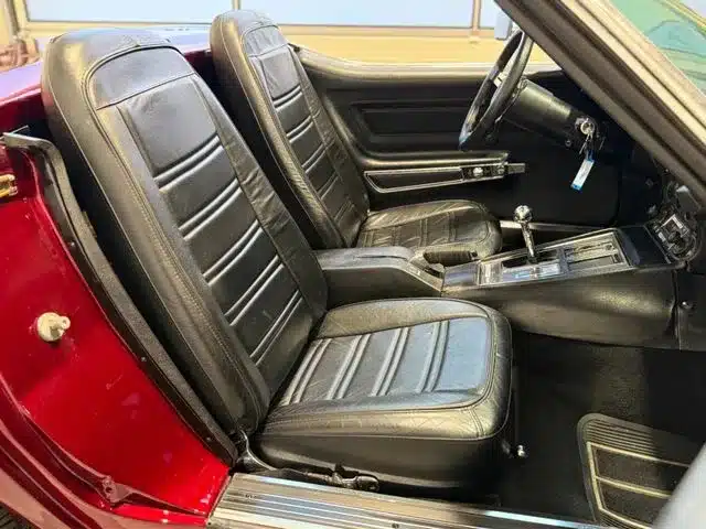 Detailaufnahme des Innenraums einer Corvette C3 Stingray Cabriolet mit schwarzer Lederausstattung und Handschaltung