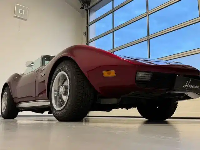 Chevrolet Corvette C3 Stingray Cabriolet in tiefrotem Candy-Lack auf einem Garagenboden