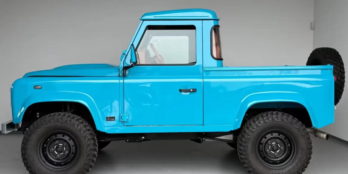 Seitliche Ansicht des Alvarez One-of-One Showcar Monaco, ein blauer Land Rover Defender TD4 Einzelstück, frisch aufgebaut mit Offroad-Bereifung.