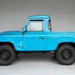 Seitliche Ansicht des Alvarez One-of-One Showcar Monaco, ein blauer Land Rover Defender TD4 Einzelstück, frisch aufgebaut mit Offroad-Bereifung.