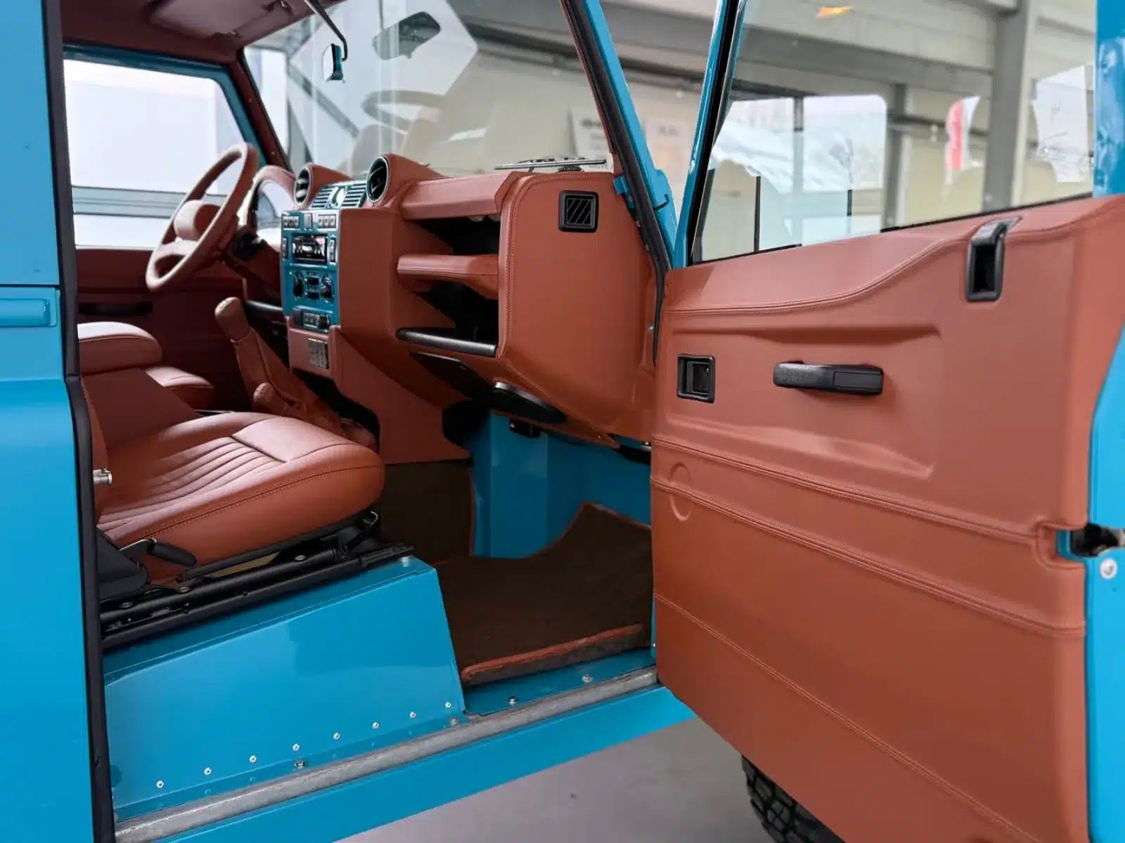 Innenraum des Defender Alvarez One-of-One Showcar Monaco mit braunen Ledersitzen und blauen Karosseriedetails