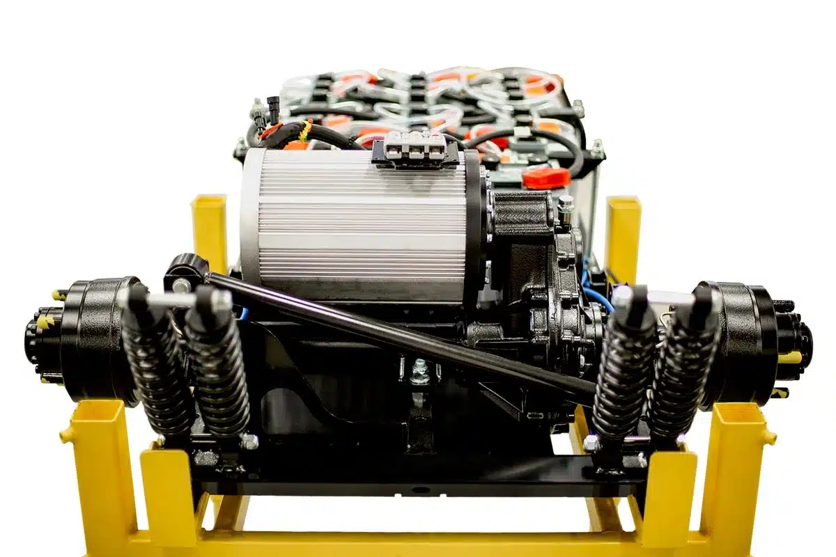Detailaufnahme des elektrischen Antriebsstrangs mit Hochvolt-Traktionsbatterie, Motor und Fahrwerkselementen des ATX340E
