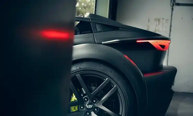 Heck des Donkervoort F22 Bare Naked mit unverkleideter Carbonkarosserie und leuchtenden Rücklichtern.