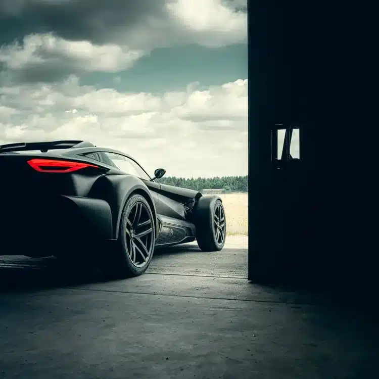 Heckansicht eines Donkervoort F22 Bare Naked mit freiliegender Carbonstruktur in einer offenen Garage.