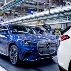 Fertigung des elektrischen Mercedes GLC in einer Produktionshalle in Bremen mit Mitarbeiterin am Fahrzeug.