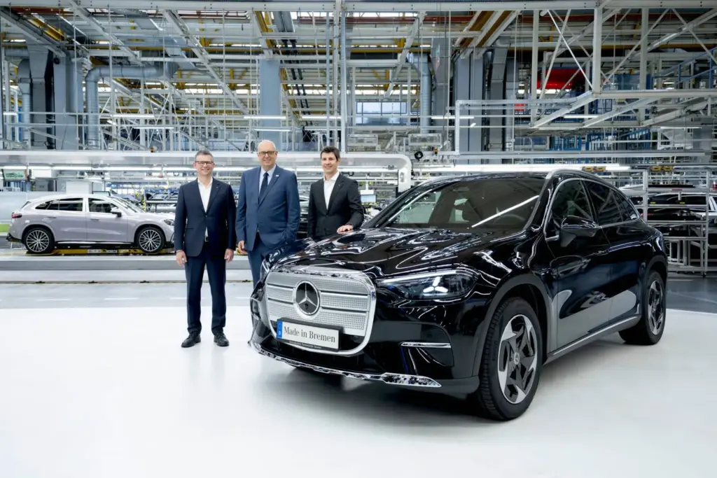 Elektrischer Mercedes-Benz GLC im Werk Bremen mit drei Personen daneben.