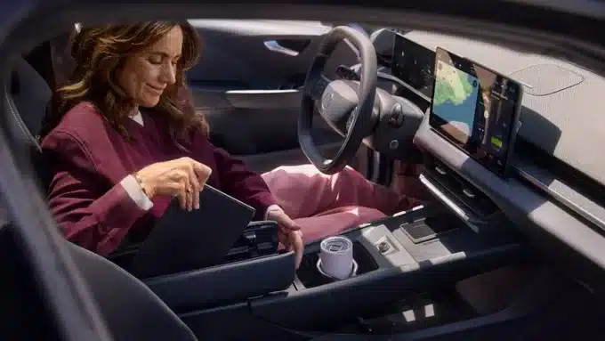 Frau sitzt im Cockpit des VW ID.3 Neo und verstaut Gegenstände in der Mittelkonsole.