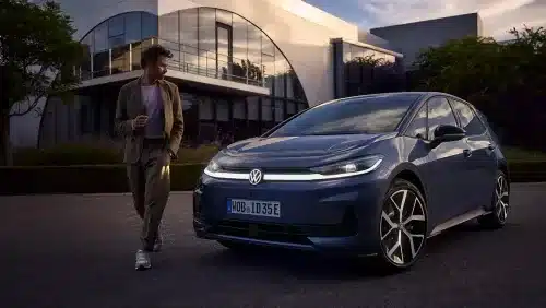 VW ID.3 Neo in blau steht vor einem modernen Gebäude, daneben steht ein Mann.