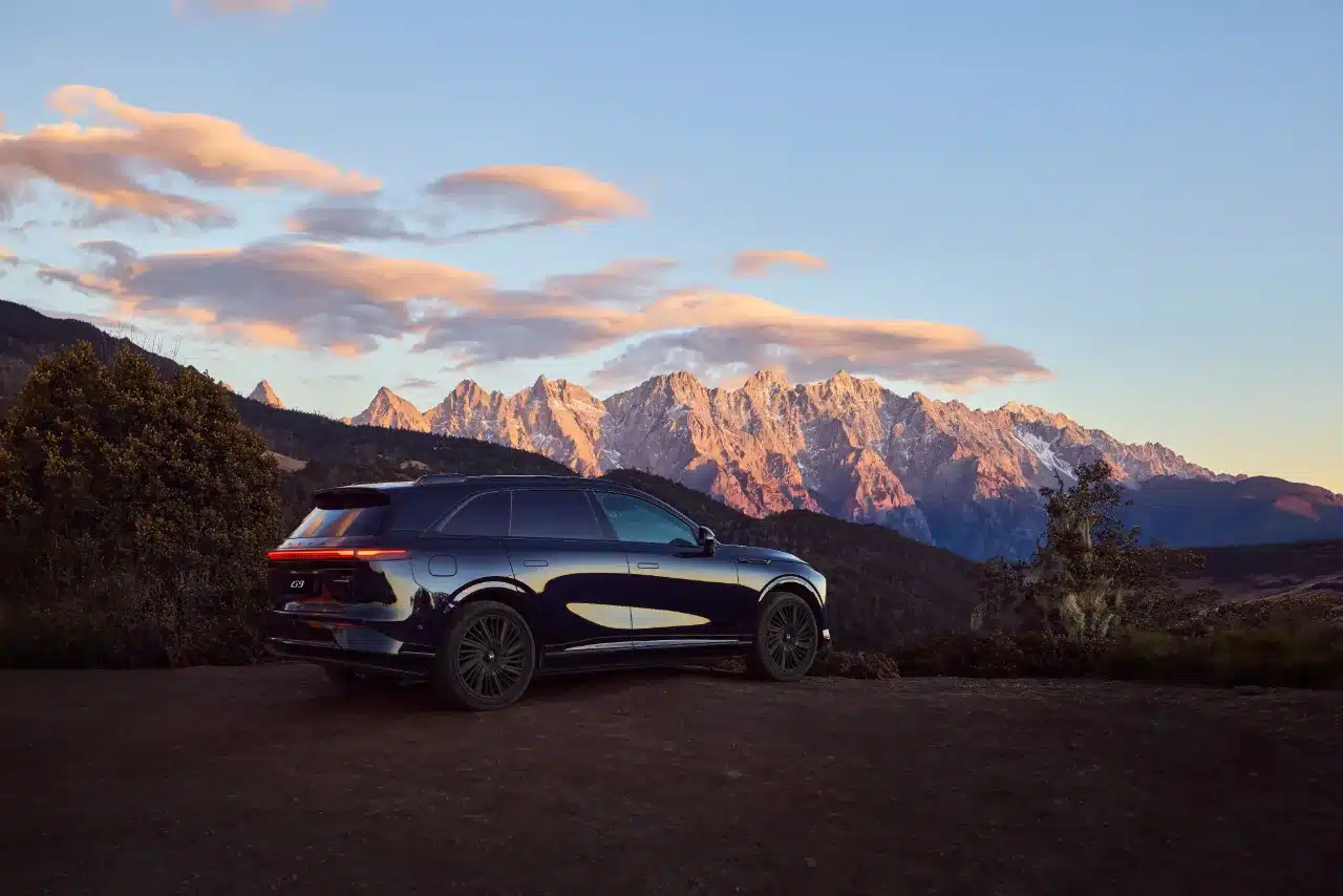 XPENG G9 SUV in Seitenansicht vor Gebirge bei Sonnenuntergang
