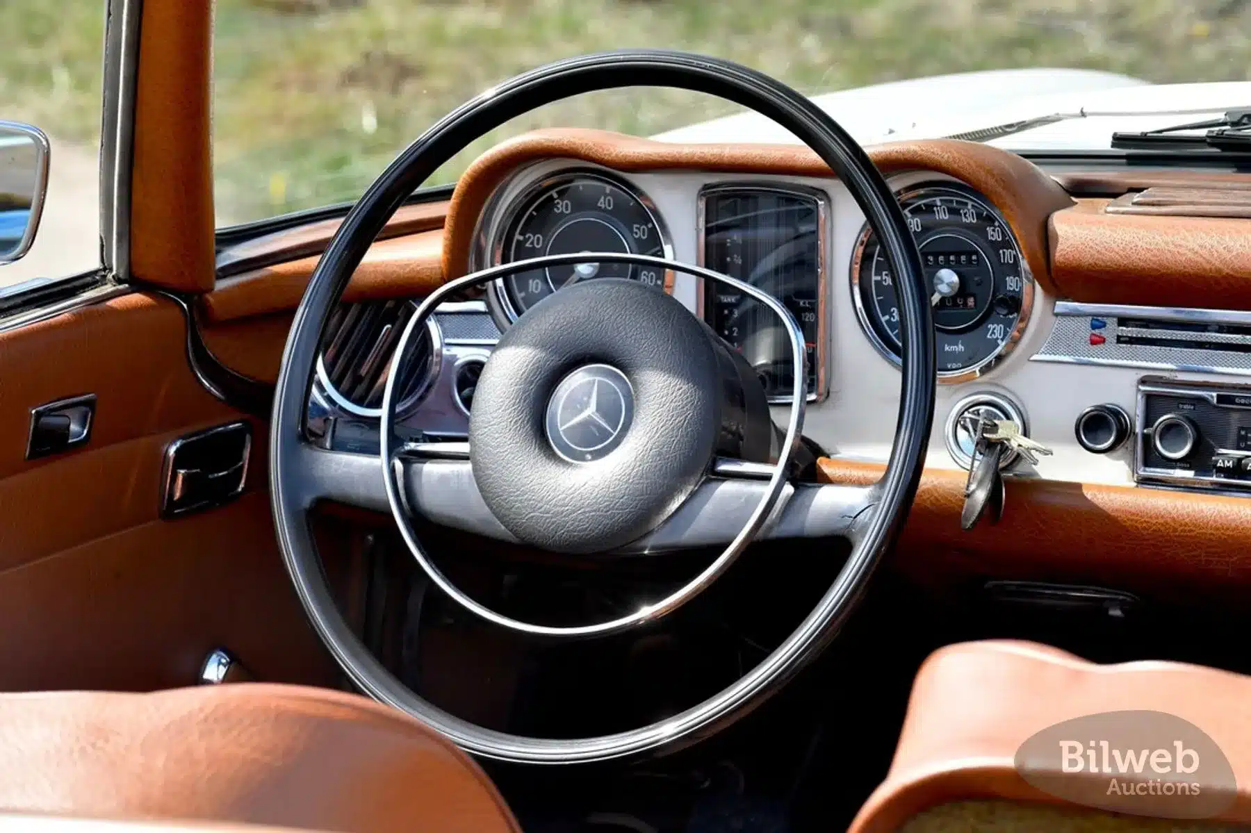 Blick auf das Armaturenbrett und Lenkrad eines Mercedes-Benz 280 SL Pagode (W113), Baujahr 1968, mit brauner Innenausstattung