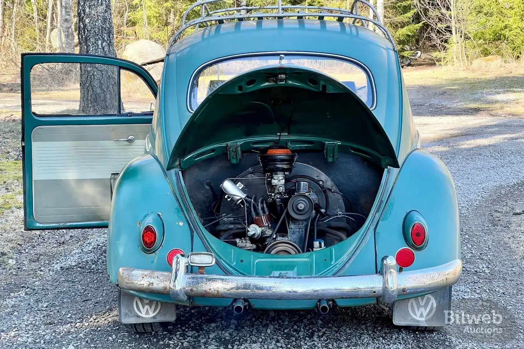 Heckansicht eines Volkswagen Käfer 1200 von 1960 mit geöffnetem Motorraum, sichtbarem Boxermotor und unpolierter Karosserie.