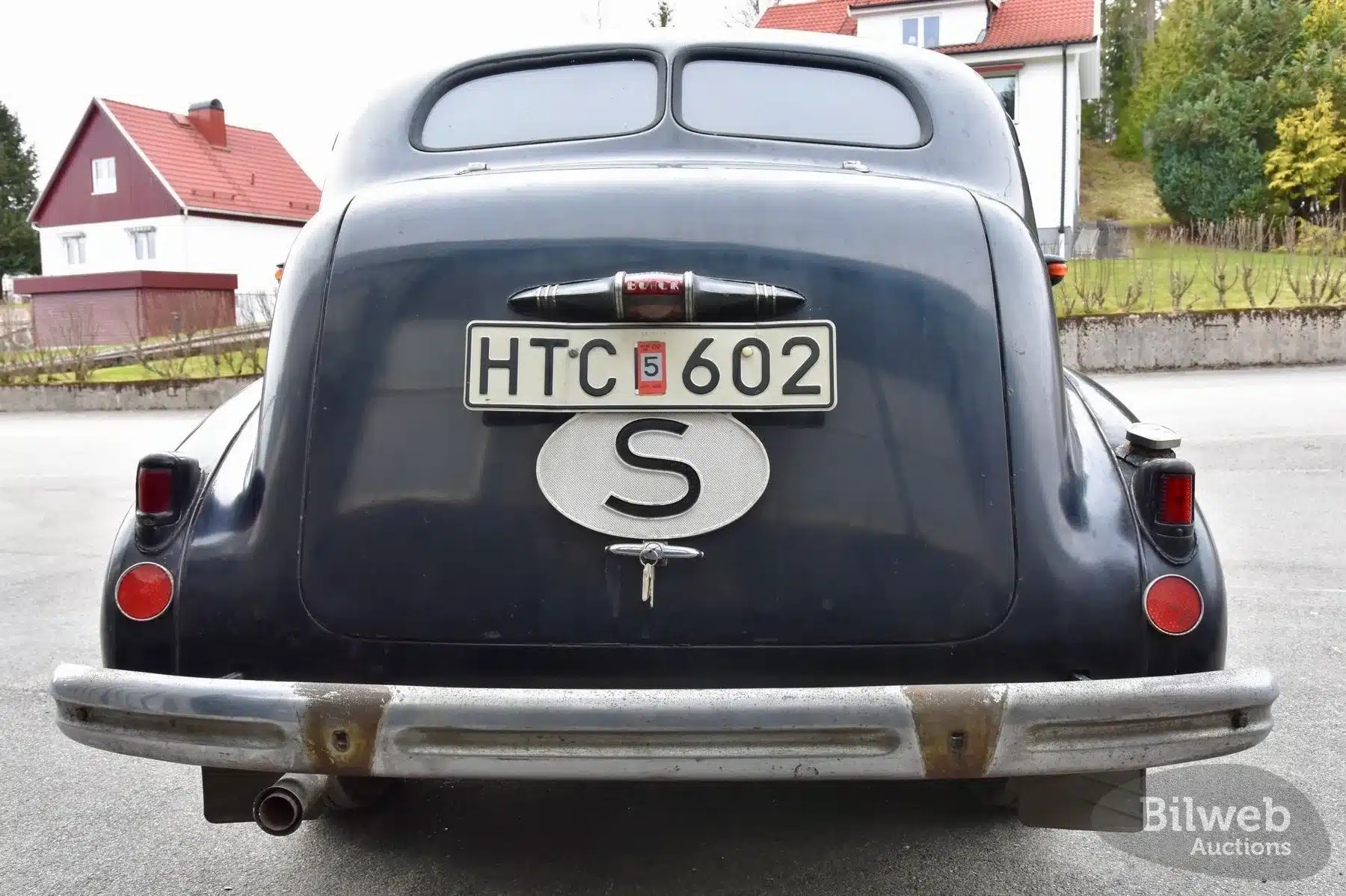 Heckansicht eines schwarzen Buick Special Saloon Straight 8 von 1937 mit schwedischem Nummernschild und S-Landeszeichen, Patina und sichtbarem Chromstoßfänger.