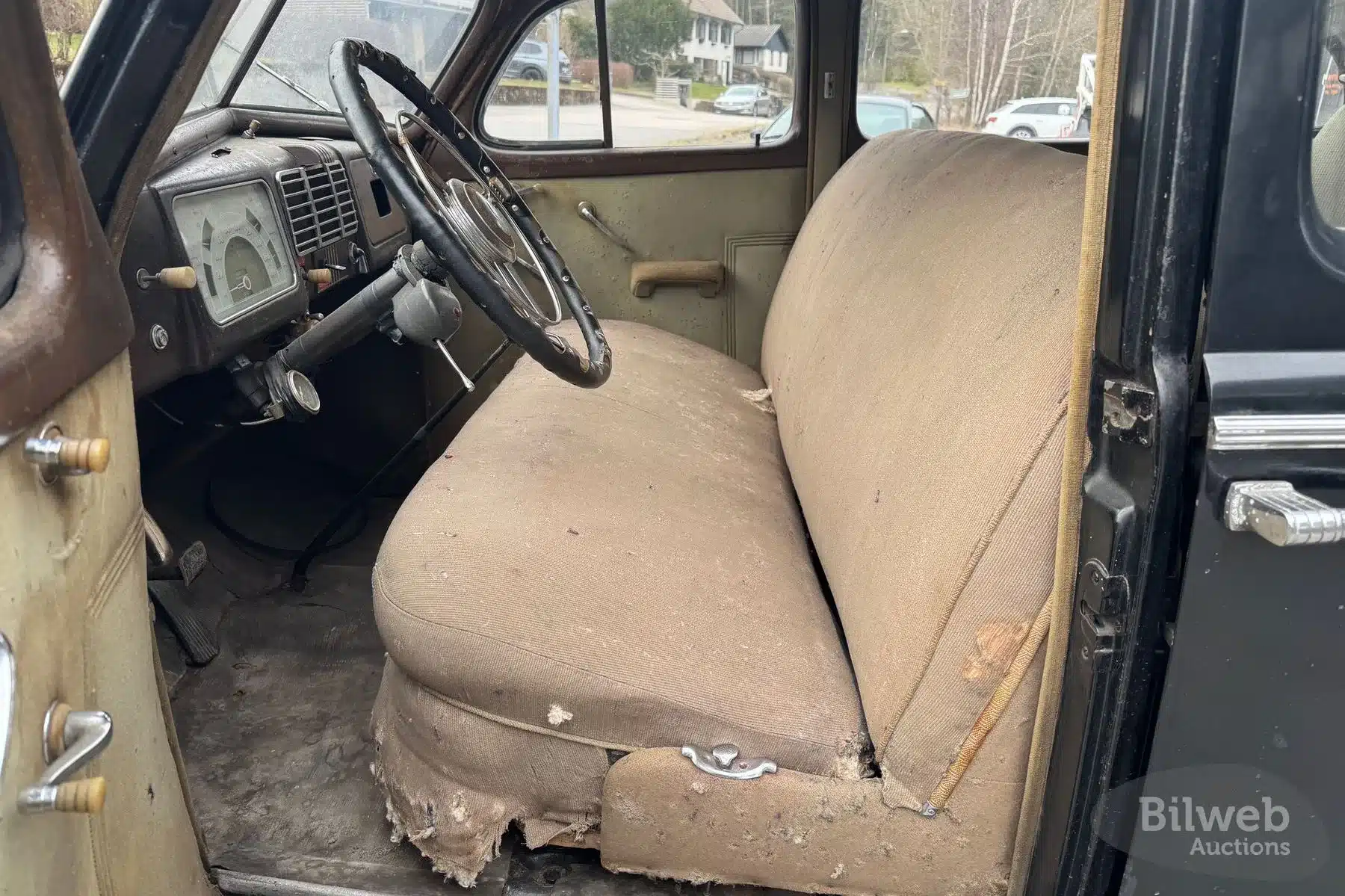 Innenraum eines 1937er Buick Special Saloon Straight 8 mit stark abgenutzten Sitzen und Lenkrad.