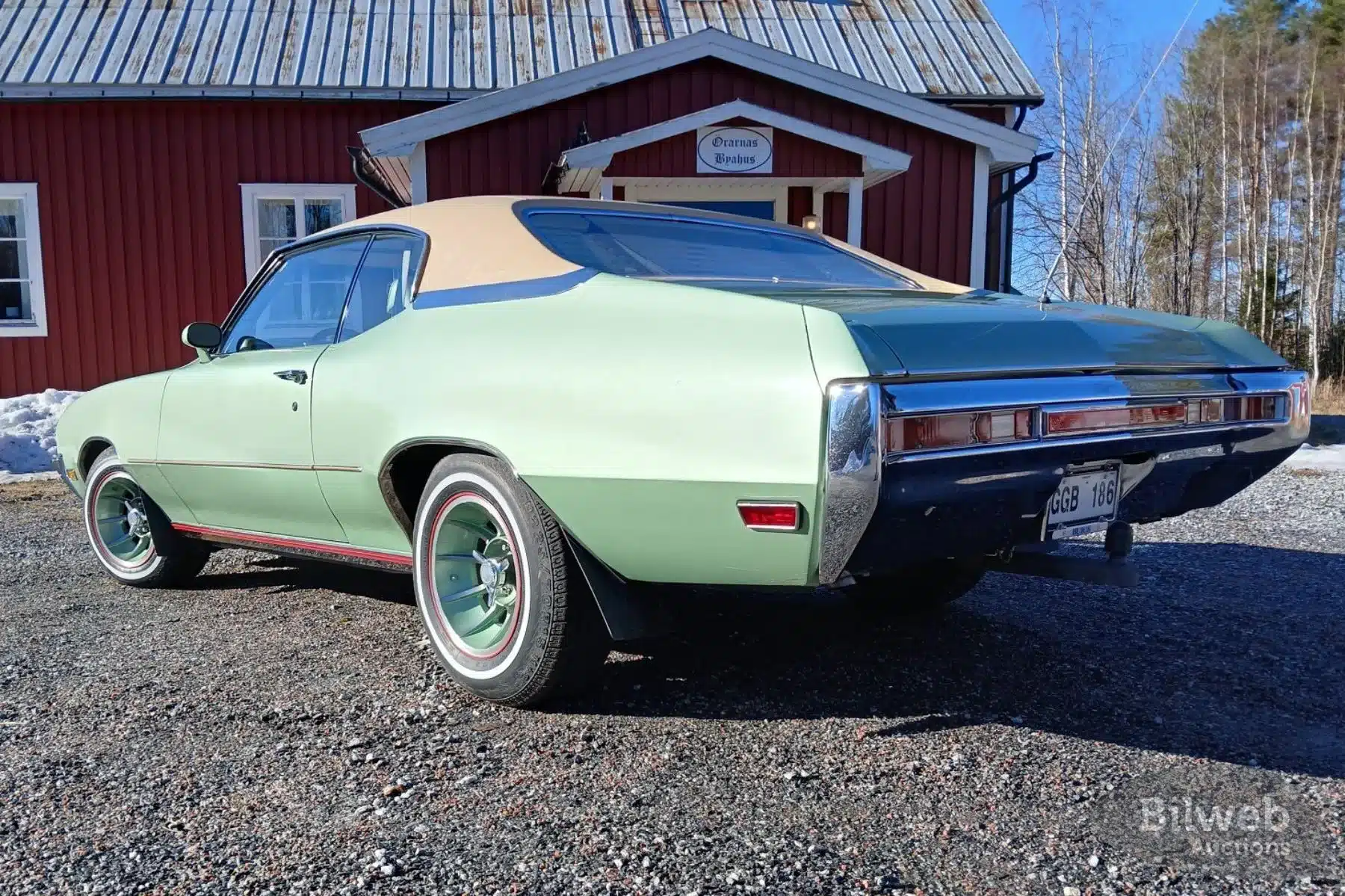 Buick Skylark Custom Sport Coupé V8 von 1970 in hellgrün mit Vinyl-Dach, Heckansicht, vor einem schwedischen Haus.