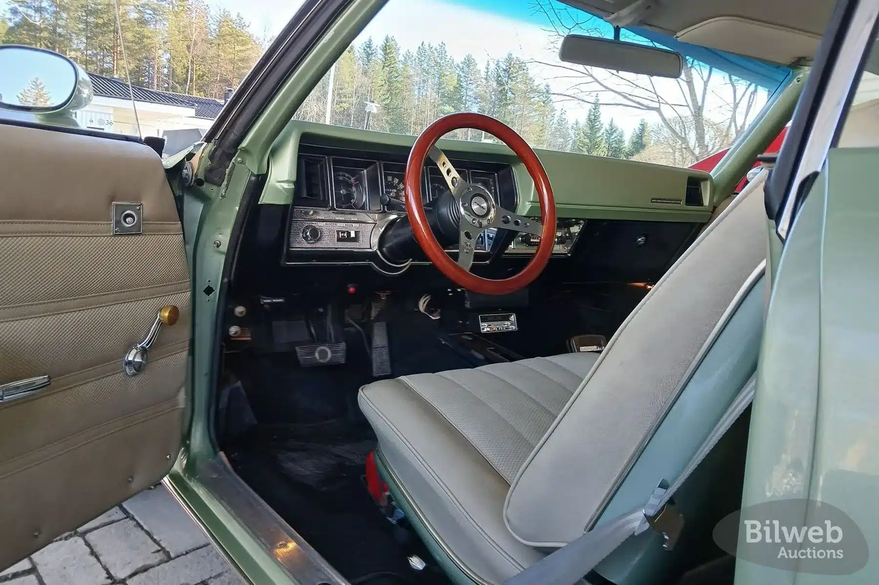 Innenansicht des Buick Skylark Custom Sport Coupé V8 von 1970 mit hellgrüner Armaturentafel und Holzlenkrad.