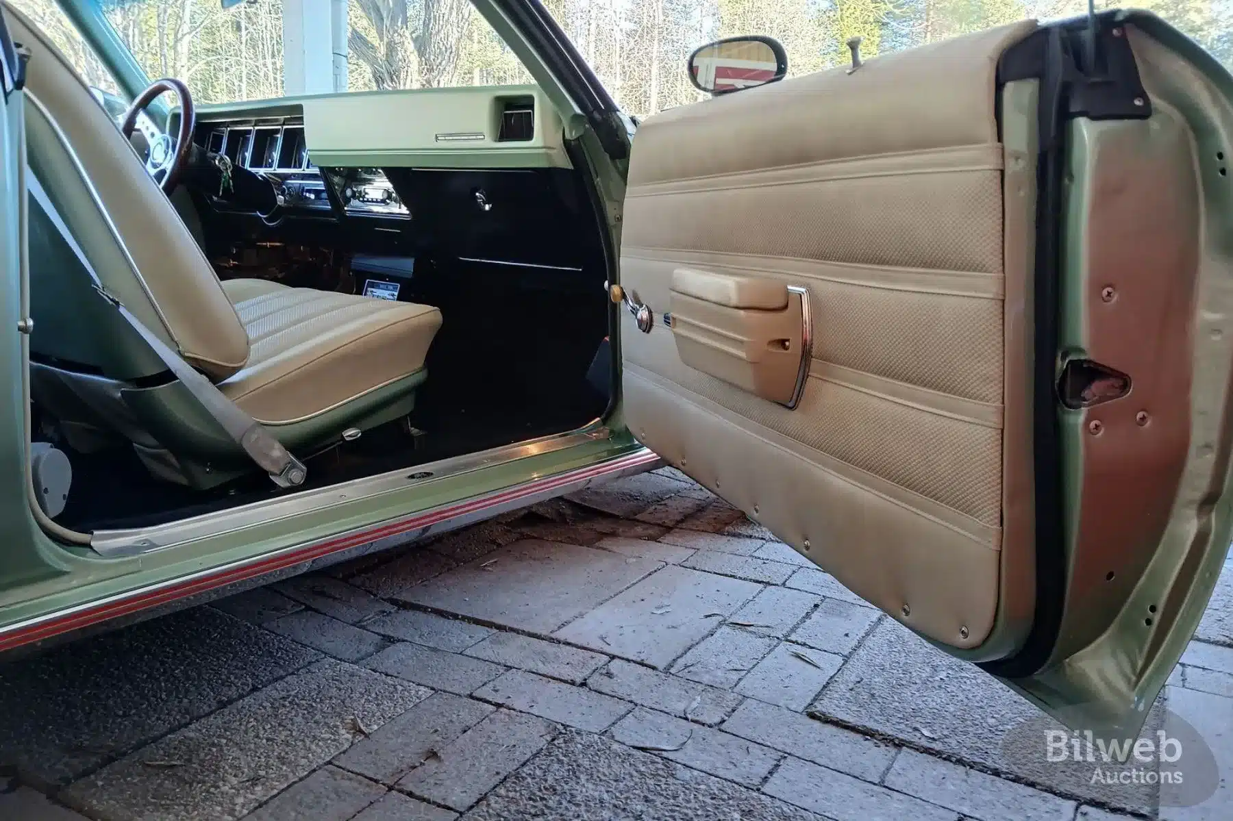 Innenraumansicht eines Buick Skylark Custom Sport Coupé V8 aus dem Jahr 1970 mit beiger Lederausstattung und geöffnetem Fahrertür.